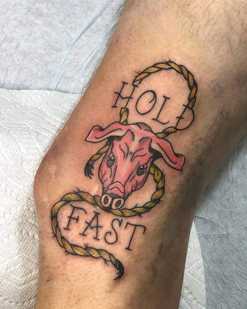 Tattoo of a bull's head with the words "Hold Fast" and a twisted rope design