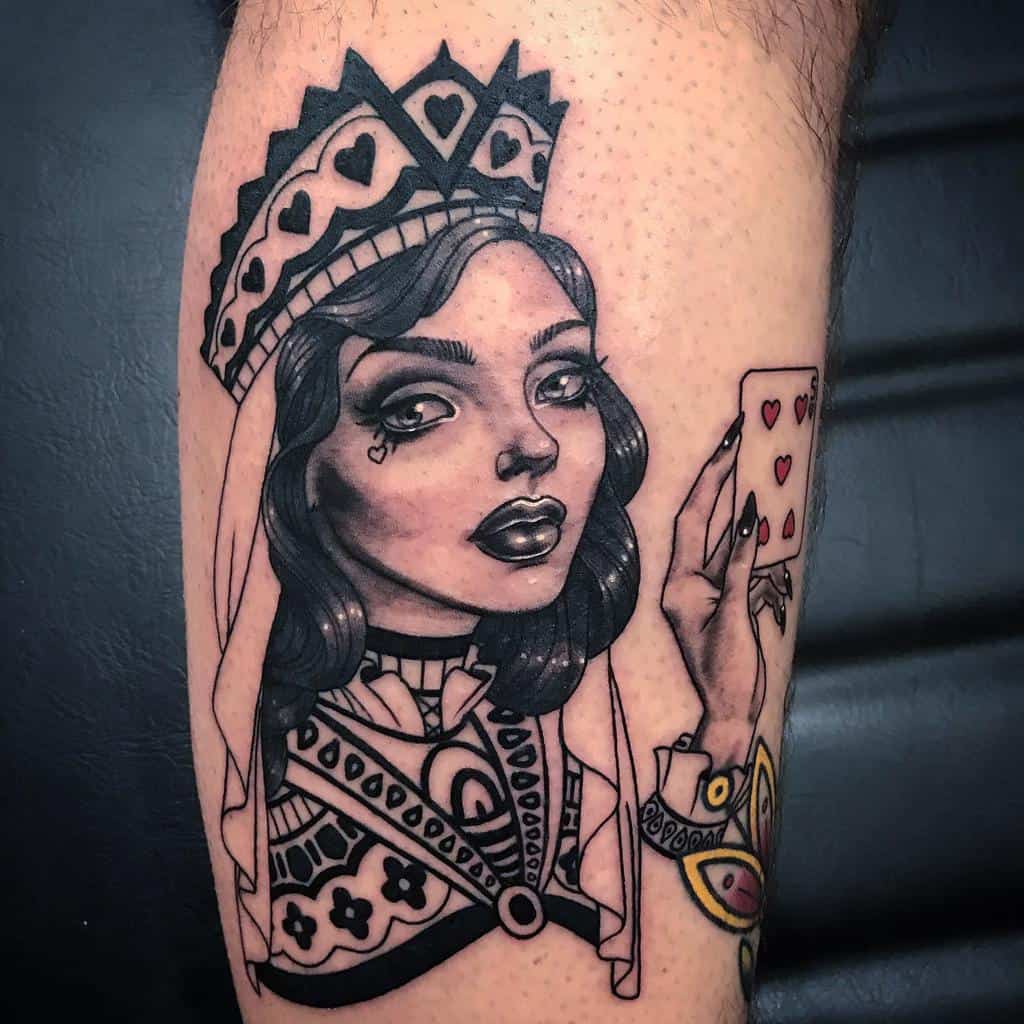 Tattoo of a queen of hearts holding a card in black and grey