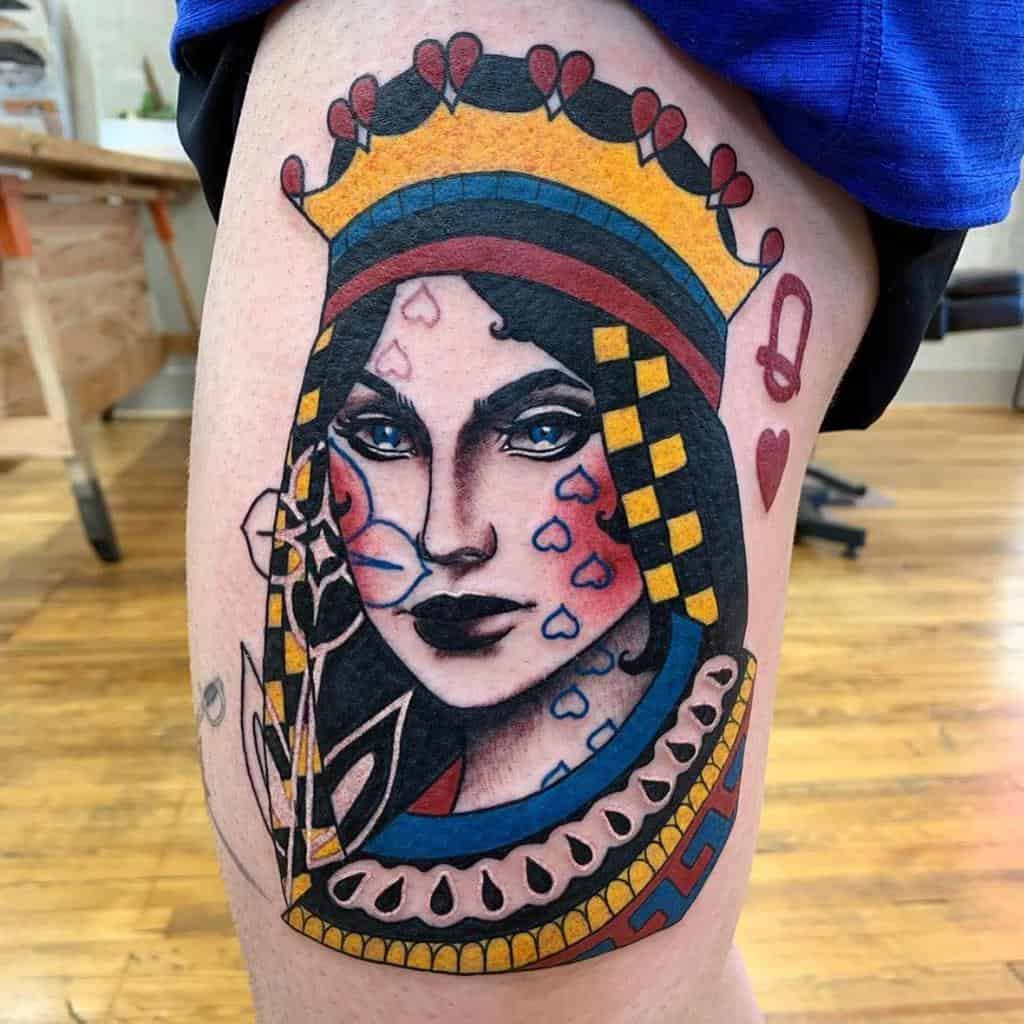 Bold Queen of Hearts tattoo featuring a regal woman with striking blue eyes, intricate details, and heart motifs