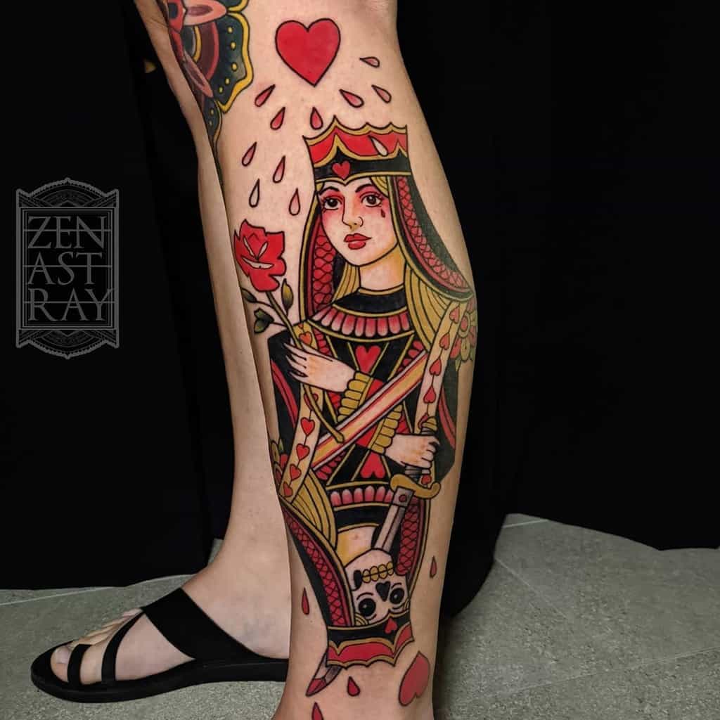 Queen of Hearts tattoo with bold red and black ink, featuring a playing card design, a rose, and dripping hearts