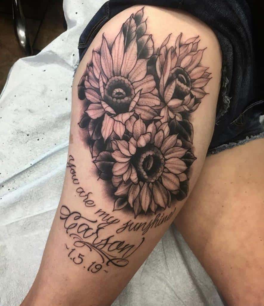 Tattoo of sunflowers with the text "You are my sunshine, Jackson 7.5.19" on a thigh