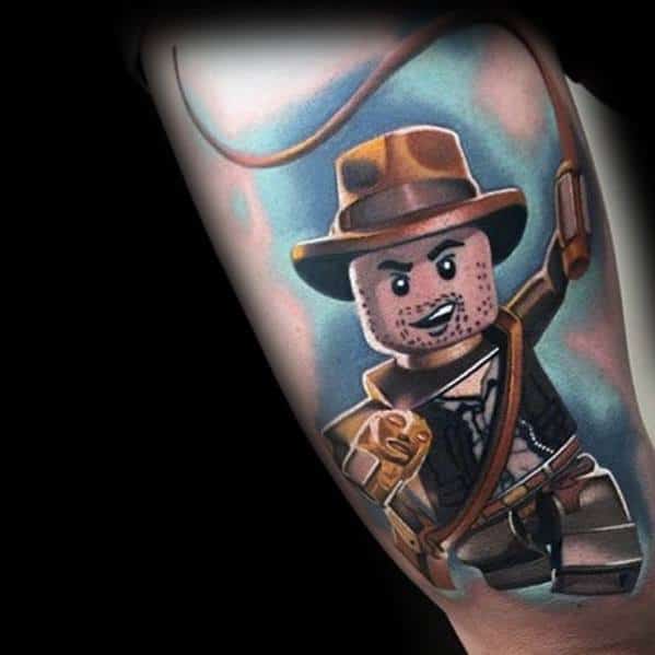 A vibrant tattoo of LEGO Indiana Jones, featuring bold colors, dynamic shading, and intricate details, capturing the adventurous spirit.