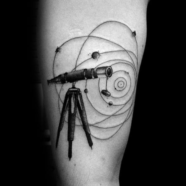Tattoo of a telescope with orbiting planets and celestial symbols on an arm