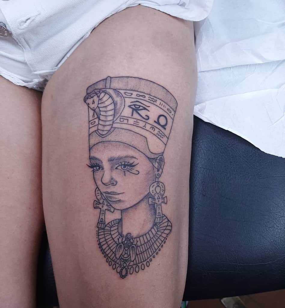 Thigh tattoo of an ancient Egyptian queen with a headdress and jewelry