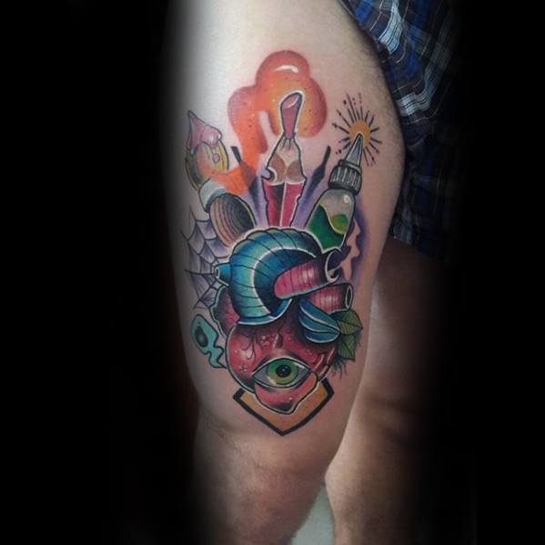 Tattoo of a heart intertwined with art supplies and vibrant pencil designs on a person's upper leg