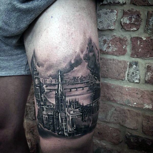 Detailed black and grey tattoo on the thigh, featuring Big Ben, the Tower Bridge, and a dramatic sky, with intricate shading and architectural details.