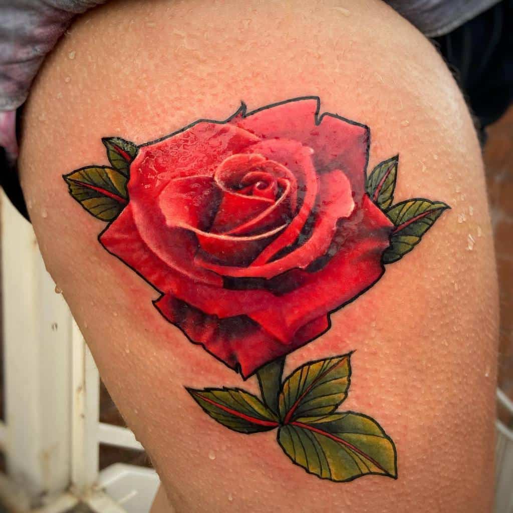 Vibrant red rose tattoo with green leaves on a thigh