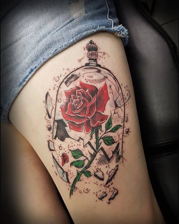Vivid thigh tattoo of a red rose encased in a shattered glass dome, symbolizing beauty and fragility with intricate details
