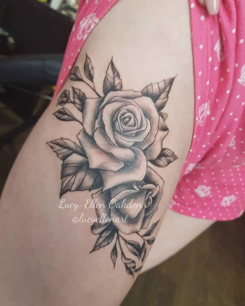 Tattoo of two roses with leaves on a  thigh 