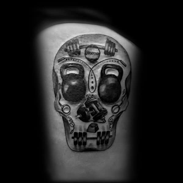 Intricate skull tattoo with kettlebells, barbells, and gym equipment integrated into the design, symbolizing strength, endurance, and dedication to fitness.