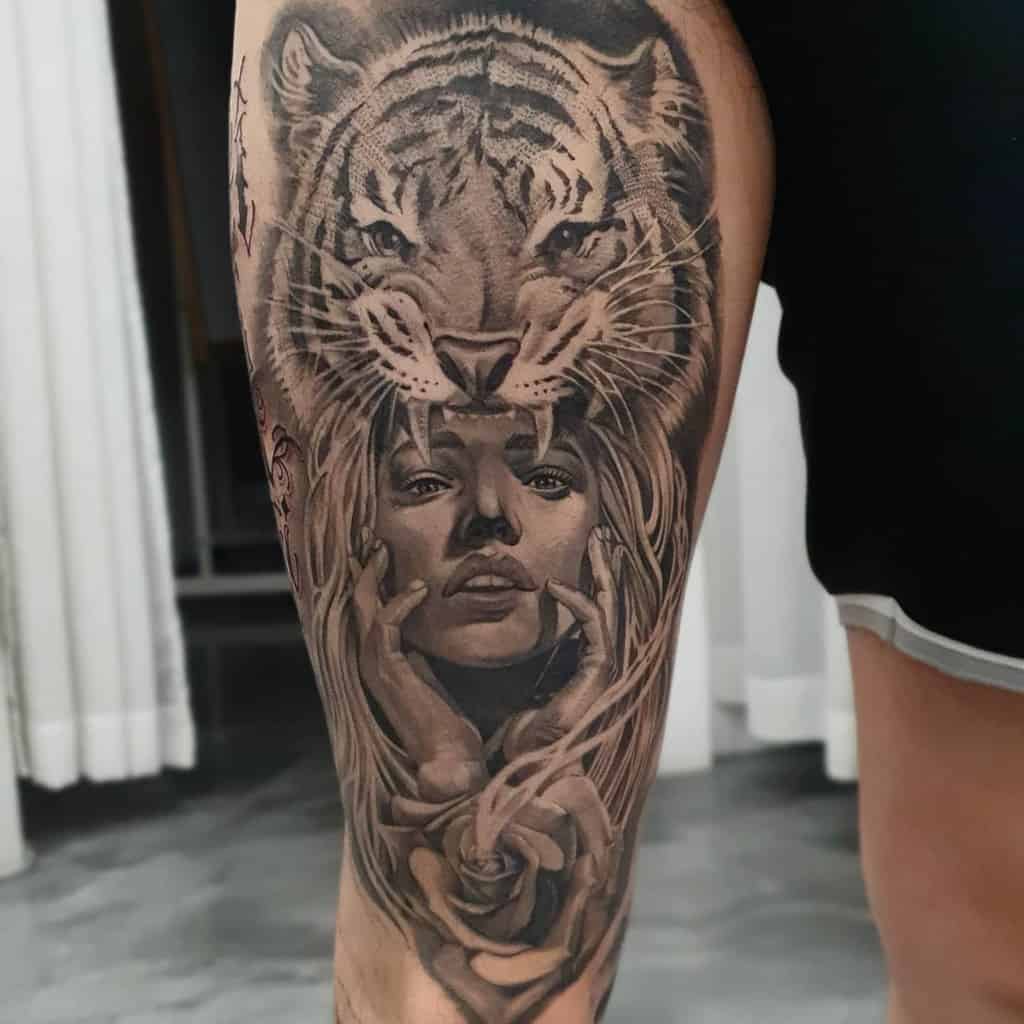 Tattoo of a tiger above a woman's face with hands and a rose on a thigh