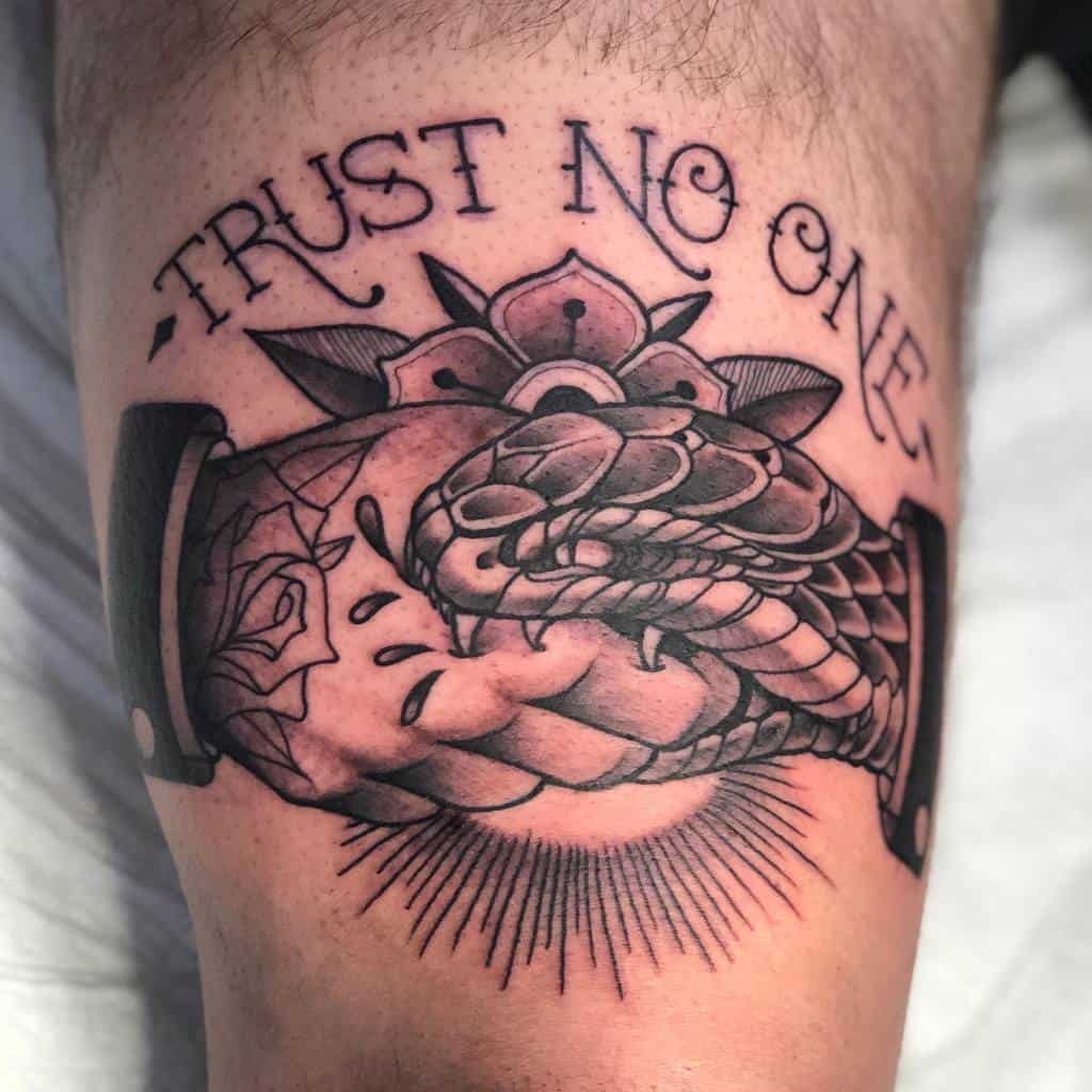 Black and grey thigh tattoo of a handshake entwined with a snake, adorned with a flower and 'Trust No One' text