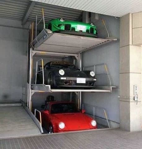 A compact three-story Porsche garage with a vertical lift system for efficient storage.






















