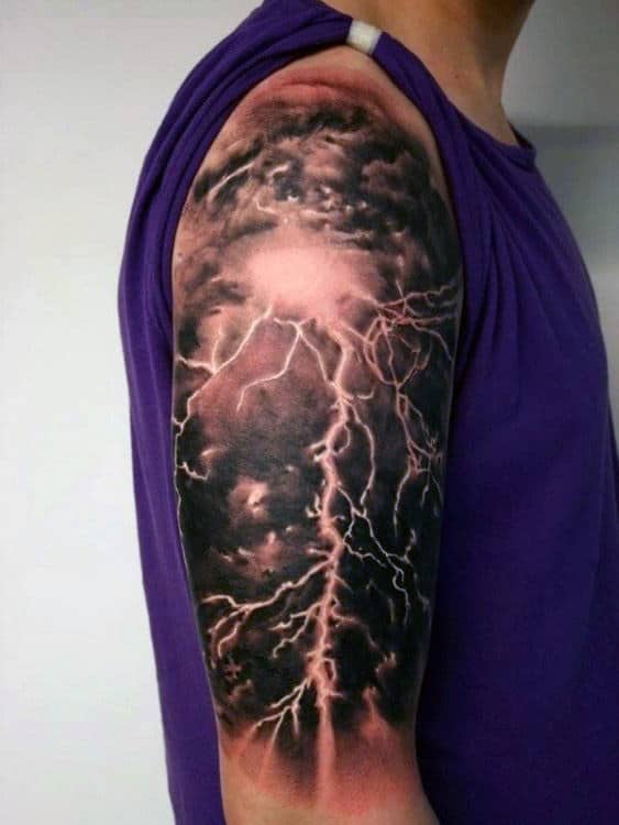 Tattoo of a stormy sky with lightning on a person's upper arm