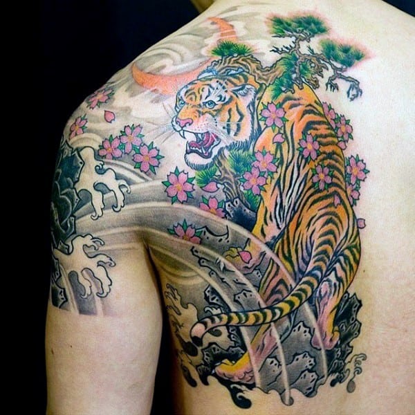 Vibrant Japanese-style back tattoo featuring a fierce tiger among cherry blossoms, crashing waves, and a bonsai tree for a dynamic look