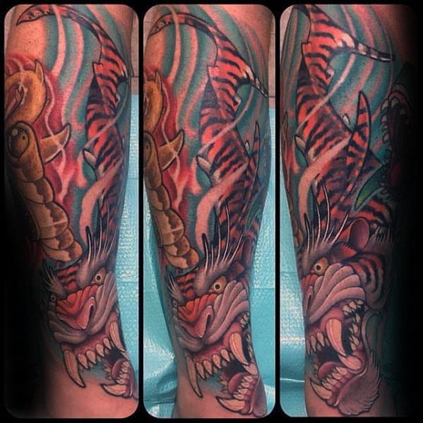 Full sleeve tiger shark hybrid tattoo with fierce expression, swirling water, and bold red and blue tones in a vibrant Japanese-inspired style.