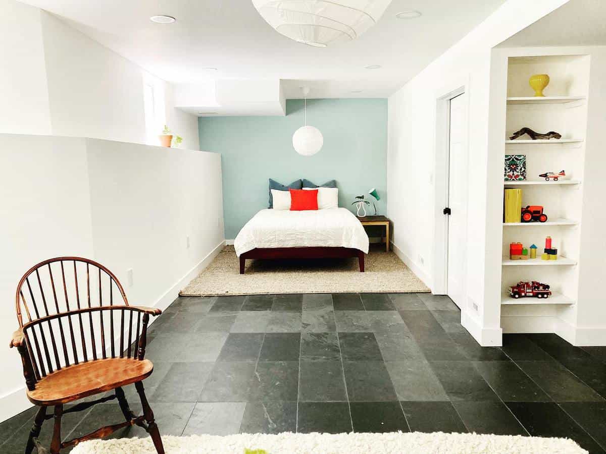 Bright children's bedroom with a wooden chair, slate floor, and built-in toy shelf.