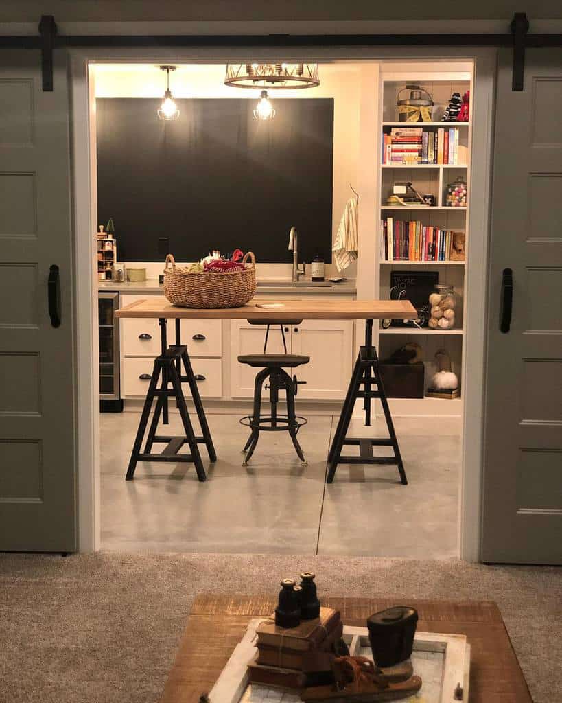 Cozy kitchen with concrete floors, wooden table, open shelves, and sliding barn doors.