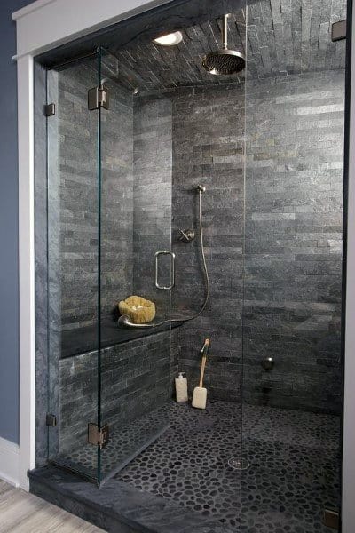 Grey granite tile shower with pebble floor, built-in bench, and glass enclosure.