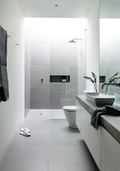 Minimalist bathroom with gray concrete floor tiles and a walk-in shower.