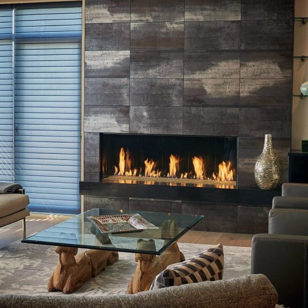 Modern tiled fireplace with linear flames, glass coffee table, and cozy living room decor.