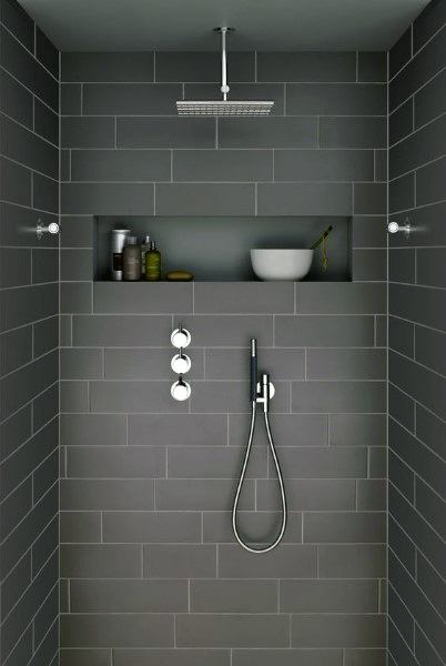 Grey matte ceramic tile shower with recessed shelf, rainfall showerhead, and modern fixtures.