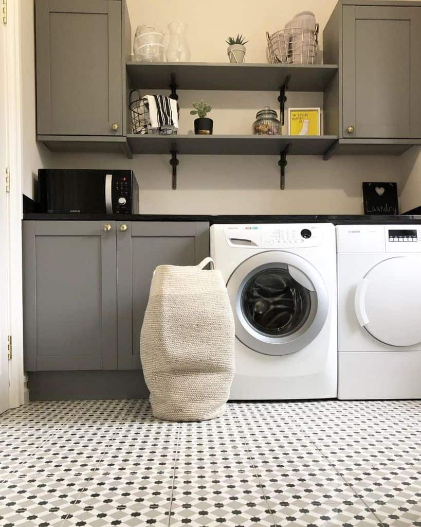 gray cabinet laundry room tile floor washer and dryer