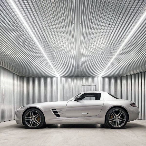 Minimalist garage with corrugated metal walls and ceiling, featuring a sleek silver sports car.