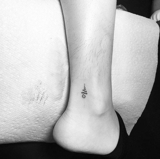 Minimalist Unalome tattoo on the ankle, symbolizing spiritual growth, enlightenment, and the path to inner peace.