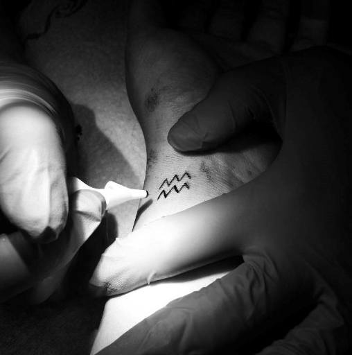 Tiny Aquarius Black Ink Wrist Tattoos