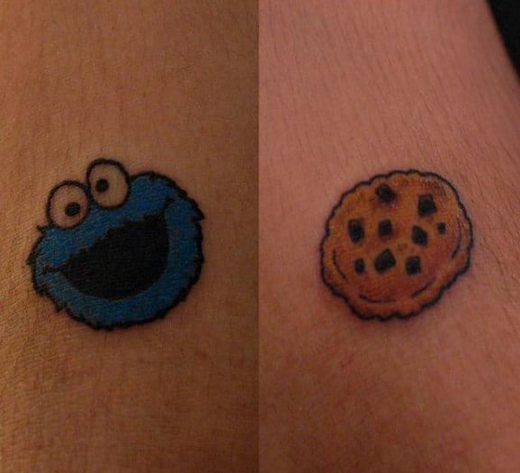 Matching mini tattoos of Cookie Monster’s happy face and a chocolate chip cookie, both done in a cute and simple cartoon style.