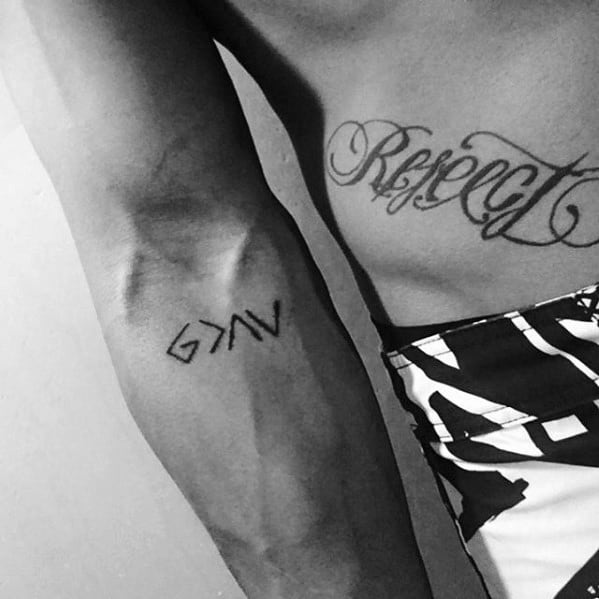 Arm tattoo featuring the "God is greater than the highs and lows" symbol in bold black minimalist style