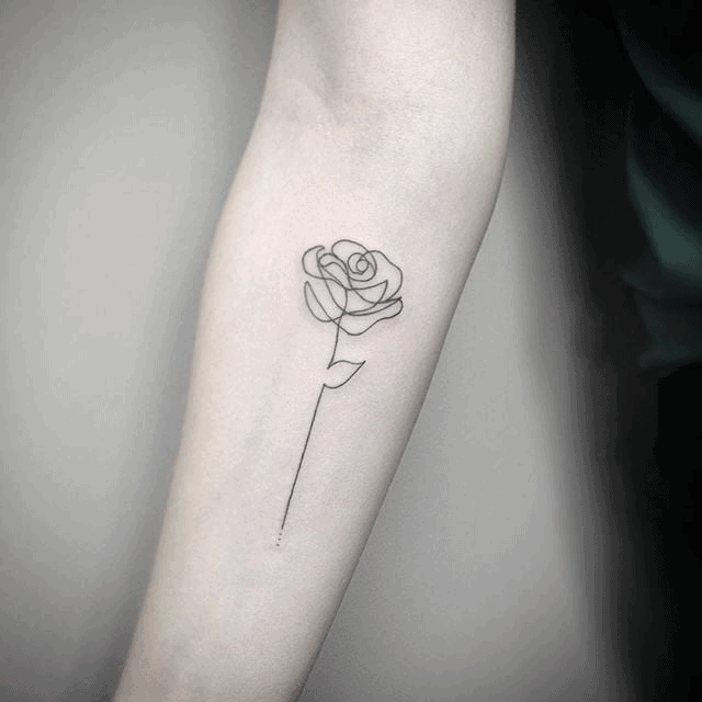 Minimalist fine-line tattoo of an enchanted rose with a delicate, long stem, placed elegantly on the forearm.