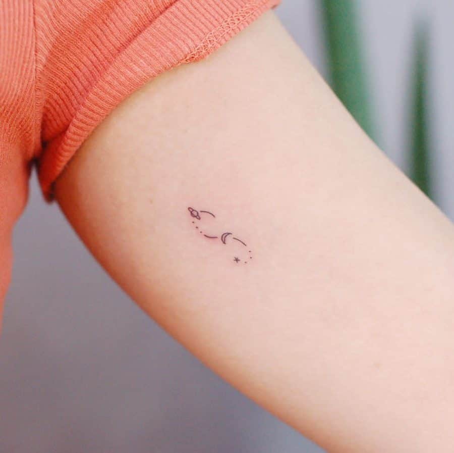 A minimalist tattoo featuring an infinity symbol with delicate stars and dots, creating a subtle yet meaningful design.