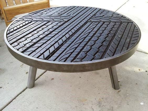 Round table with a metal frame and a top made from recycled tire tread patterns