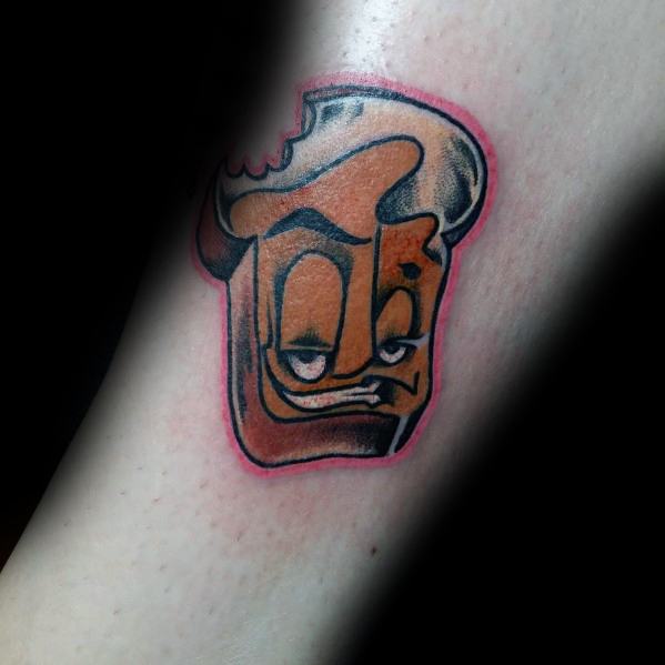 Cartoon-style toast tattoo with a mischievous face, bold outlines, and a bitten corner, blending humor with vibrant shading and a playful expression.