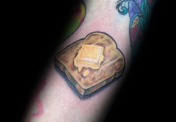 Realistic toast tattoo with melted butter, featuring warm tones, soft shading, and a three-dimensional effect for a delicious and detailed design.