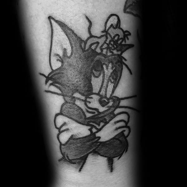 Black ink tattoo of Tom with crossed arms and Jerry sitting smugly on his head, capturing their humorous rivalry in classic cartoon style.
