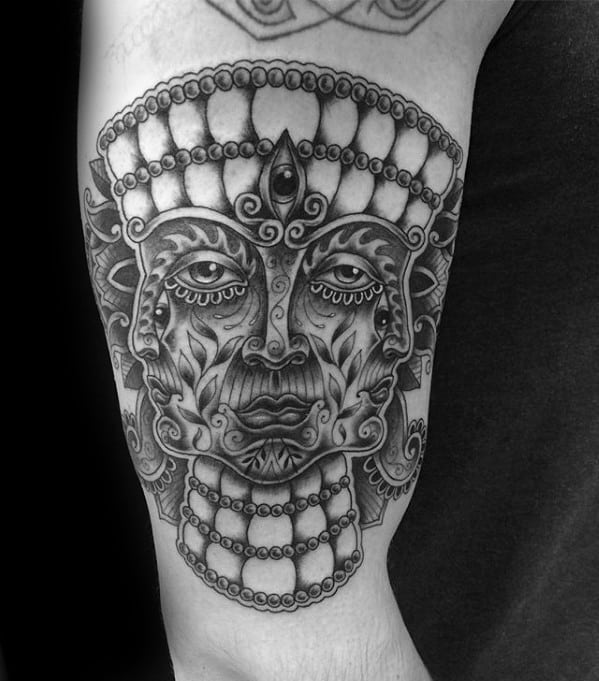 Black and grey Tool-inspired tattoo of a symmetrical, ornate face with a third eye, beaded crown, and intricate floral and geometric details.