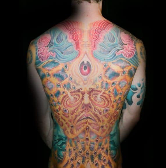 Full-back Tool-inspired tattoo with a psychedelic design featuring a central third eye, symmetrical faces, vibrant colors, and layered eyes.