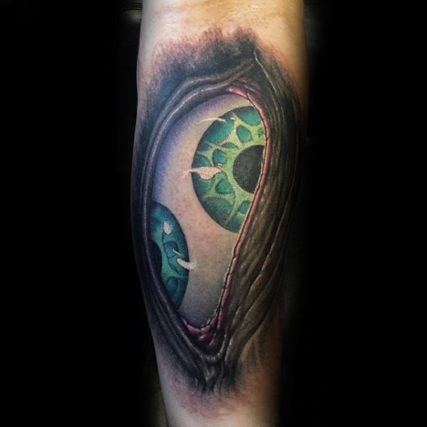 Tool-inspired tattoo of two vivid green-blue eyes peering through a realistic skin tear, with detailed shading and a surreal 3D effect.