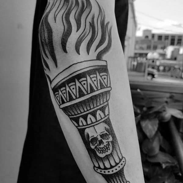 Black and grey torch tattoo with bold flames, geometric detailing, and a skull at the center of the handle for a dark, edgy vibe.