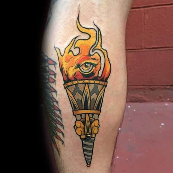 Traditional torch tattoo with yellow-orange flames forming an all-seeing eye, geometric handle, and a golden hand gripping the torch.