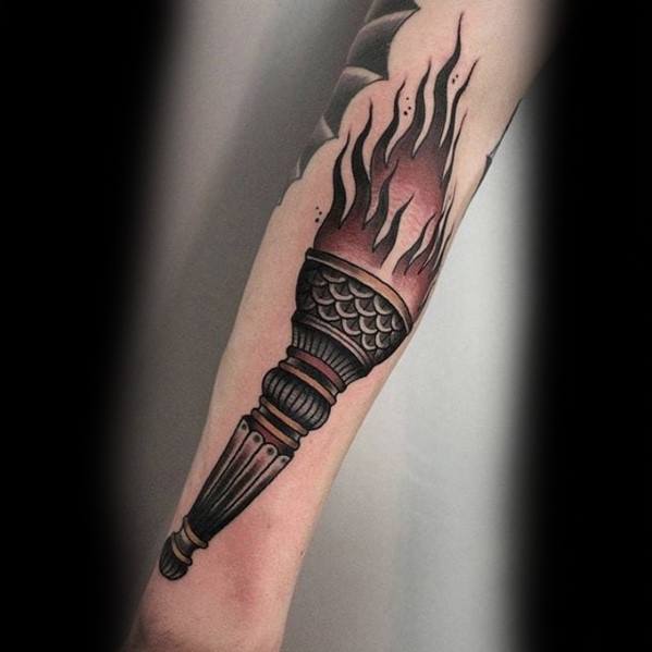 Black and grey torch tattoo with smooth shading, scale-like handle detailing, and soft black flames rising upward.