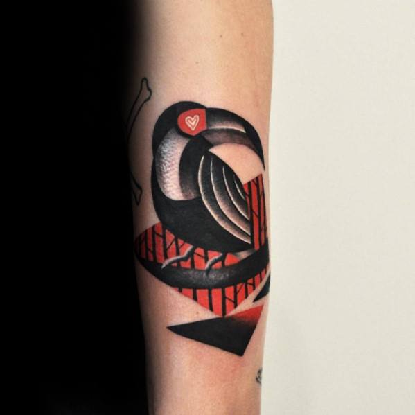 Modern abstract toucan tattoo on the forearm with bold black shading, red geometric accents, and a tiny heart detail in the eye.