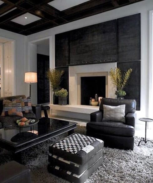 Traditional living room with leather armchair, fireplace, and dark wood ceiling design.