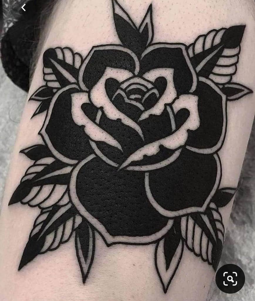 Black and white rose tattoo with bold outlines on skin