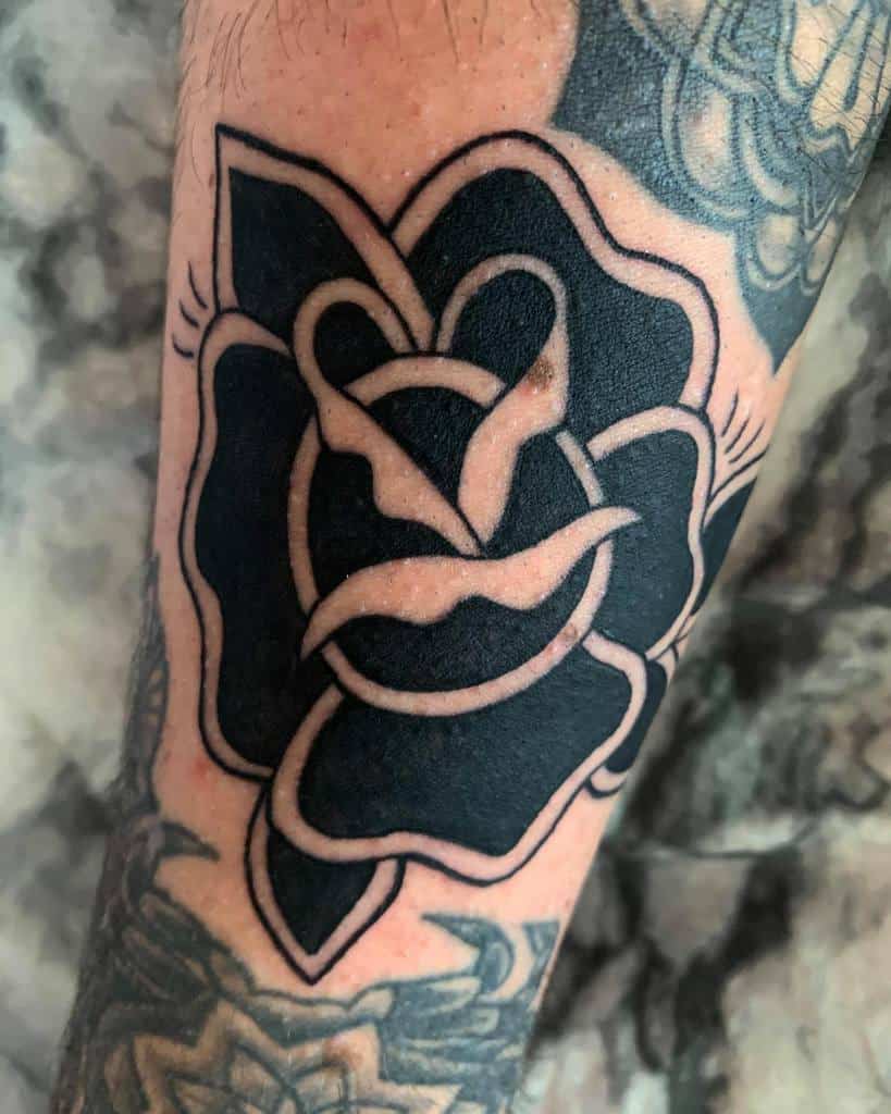 Black and white traditional style rose tattoo on forearm