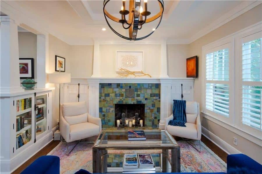 Bright living room with a tiled fireplace, cozy armchairs, and natural accents.
