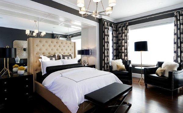 Modern bedroom with tufted headboard, black furniture, and large windows with curtains.